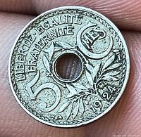 Obverse showing denomination 50 Cmes, date 1924, floral design, central hole