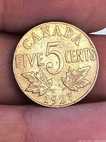Reverse of 1927 Canadian five-cent coin showing denomination, maple leaves, date