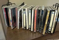 Left side view of CDs in rack showing spines and rack end