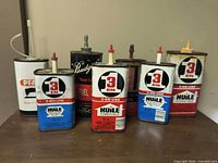 Front view of all seven tins standing on table