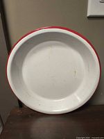 Top view of white enamel dish with red rim