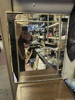 Front view of rectangular mirror showing brass-tone frame and reflective surface