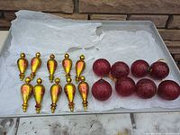 Tray showing all 18 ornaments: 10 gold teardrop and 8 red ball