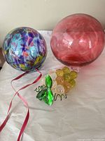 Overview of three ornaments: multicolour swirl ball, pink/red ball, faceted grape cluster