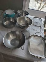 Group view of all bowls, colander, strainers, tray and plastic pieces