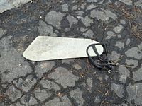 Full view of rudder blade, mounting frame, and attached control cables on pavement