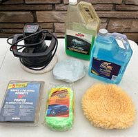 Group shot showing polisher, bonnet kit, two car wash jugs, sponge, microfiber cloth, wool pad