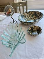 All four items group view: glass leaf dish, two ceramic bowls, metal sun candle holder