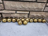 Full set of twelve gold crackle glass ornaments lined up to show quantity and overall appearance