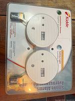 Front view of sealed 2-pack Kidde smoke alarms with batteries