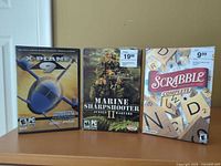 Front view of all three game cases upright on shelf