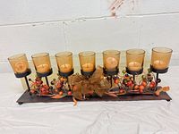 full view of centerpiece showing seven amber votive holders and autumn berry decor