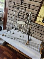 Group shot showing walker, shower stool, pair of crutches and two canes