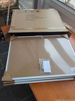 Stack of three combo boards partially in cardboard sleeves with hardware pack on top