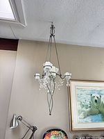 One of two matching metal and glass chandeliers hanging from ceiling