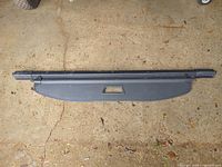 Full view of black retractable cargo cover showing cassette, shade panel and end caps