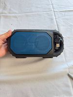 Front view showing blue grille and rugged housing