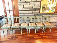 All six chairs lined up against wall showing overall style and color