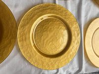 Single gold hammered charger plate showing reflective hammered surface and rim
