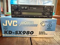 Receiver resting on JVC KD-SX980 box showing brand and model