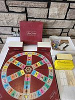 Overview of Trivial Pursuit board, card trays, playing pieces, and BrainTeasers game
