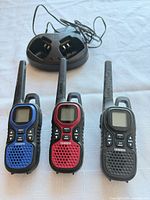 Three Uniden radios, charging cradle visible