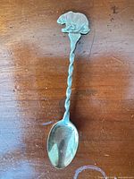 Full view of sterling spoon showing bear finial, twisted stem and bowl