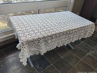 Tablecloth spread on table showing full pattern and scalloped edges