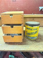 Wooden 3-drawer organizer beside Maple Leaf Tenderflake tin