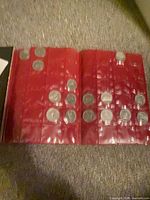 Open red plastic coin pages showing multiple coins