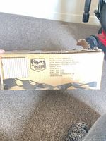 Damaged cardboard box end panel with Timber logo and barcode visible