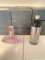 Armani Code gold cylindrical bottle beside Calvin Klein Euphoria purple curved bottle