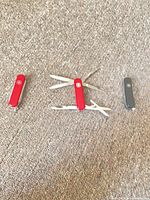 Three Wenger pocket knives, one fully opened showing tools