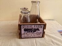 front view of three glass bottles in wooden crate