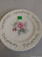 Single dinner plate showing rose motif and vine border