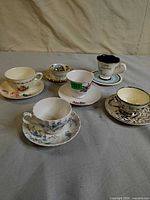Group shot of all six teacup and saucer sets on tabletop