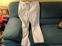 Front view of white Bandolino jeans laid flat on sofa