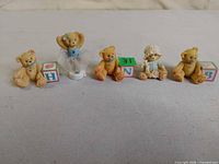 Five Cherished Teddies figurines arranged in a row, each with pastel block