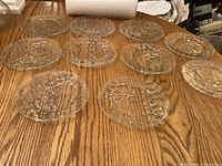 All ten clear embossed glass plates on table