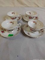 Four teacup and saucer sets displayed