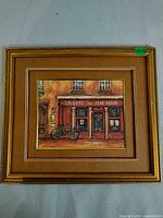 Full view of framed artwork showing gold frame, mat and image