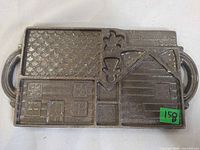 Top view of cast iron gingerbread house mold showing all cavity designs and side handles