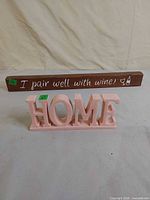 Front view showing wine quote sign and pink HOME sign