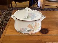 Covered oval vegetable bowl showing floral pattern, side handles, and lid