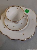 Teacup stacked on saucer and plate showing star motif and gold rims