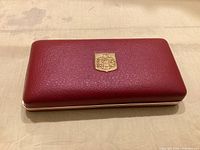 Closed red Majorica jewelry box top view showing gold crest