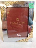 Front view of silver-tone metal frame with gold-tone corner accents and 5×7 insert