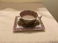 Teacup resting on rectangular saucer, full view