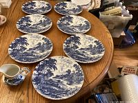Seven plates and one creamer on table, showing overall lot