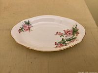 Top view of oval tray showing floral pattern and gold rim